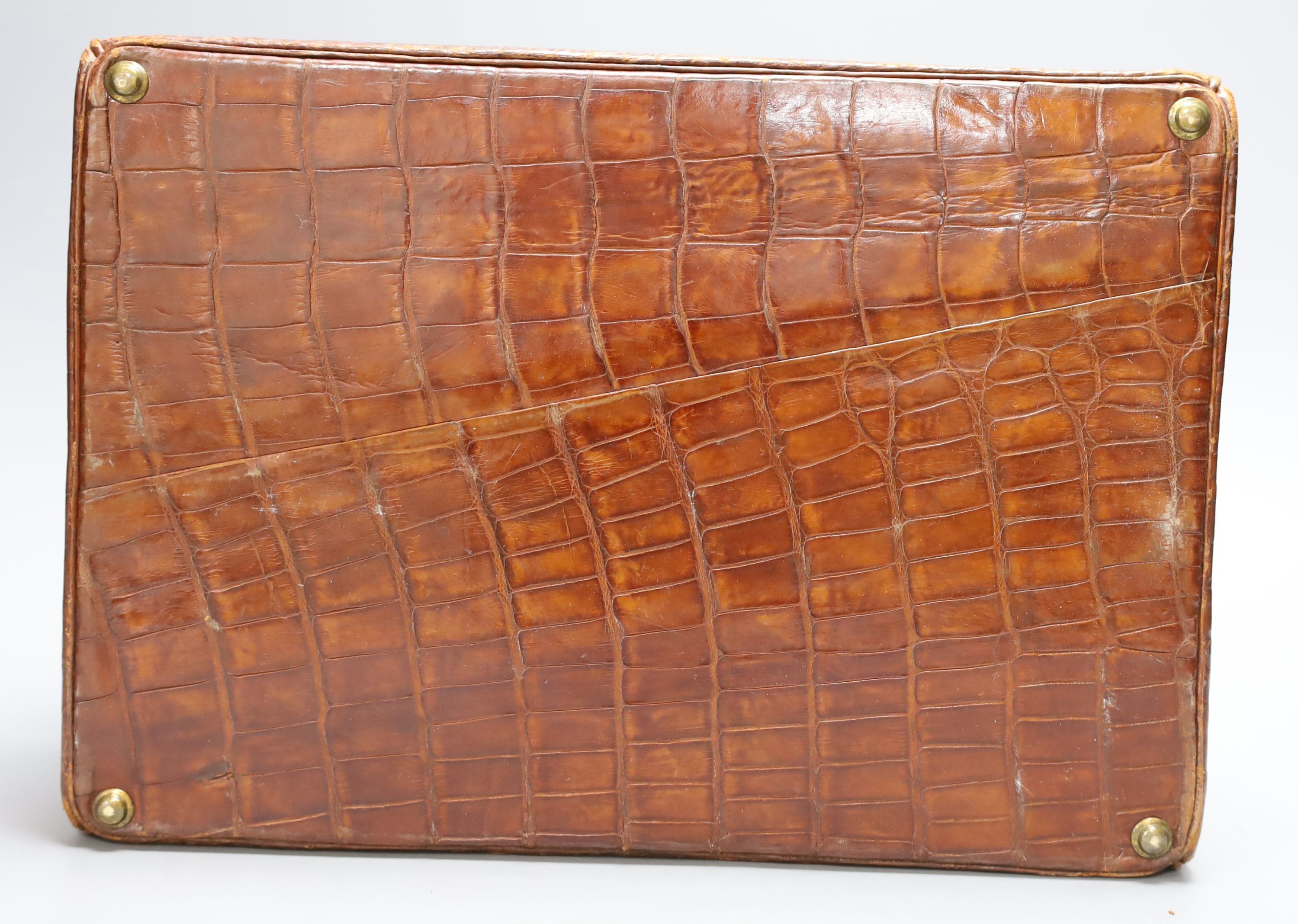 An early 20th century crocodile three tier travelling jewellery bag with key (lock a.f.) - 30cm long